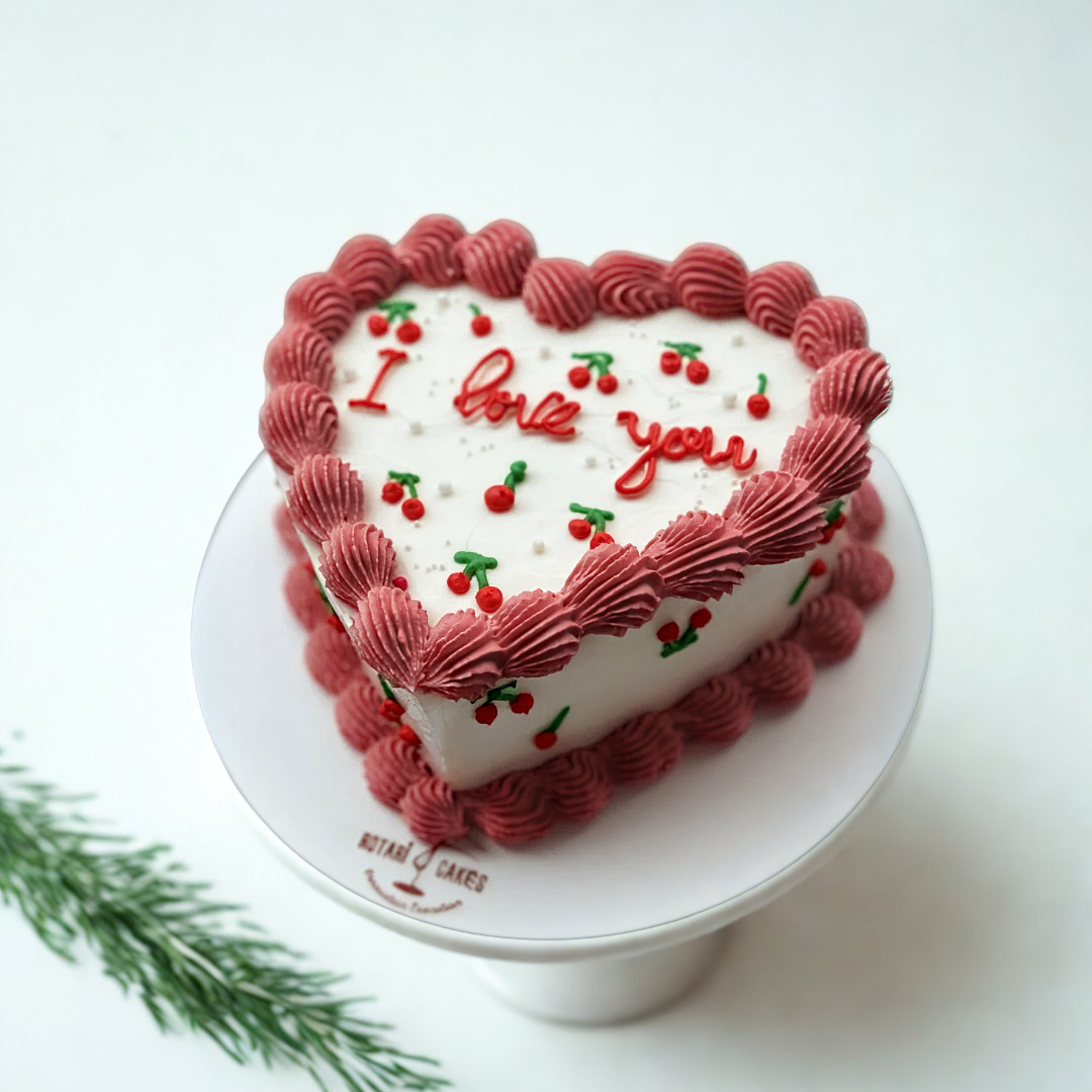 Heart shape cake with cherries on top