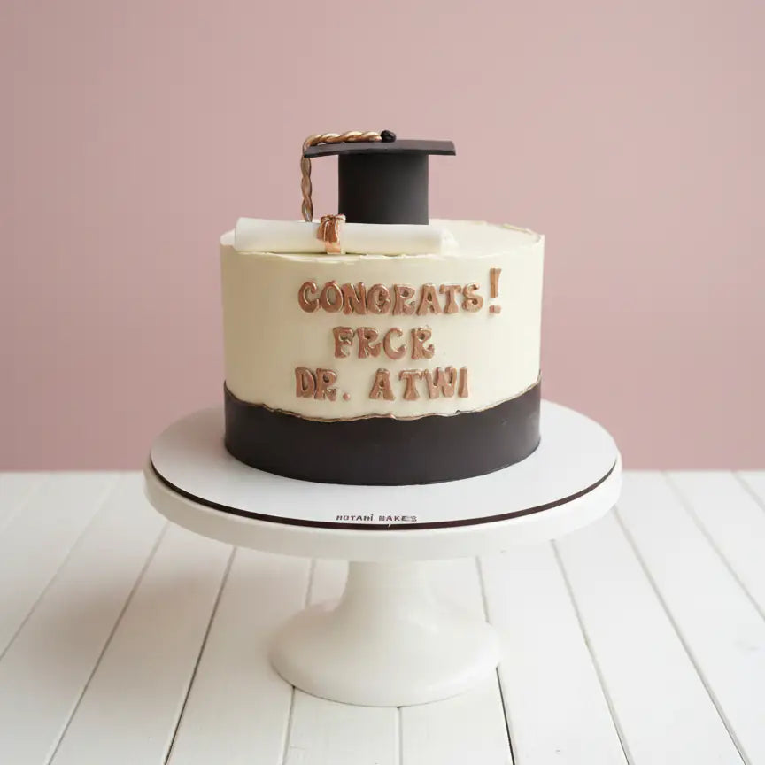 Black and white graduation cake with edible hat and diploma