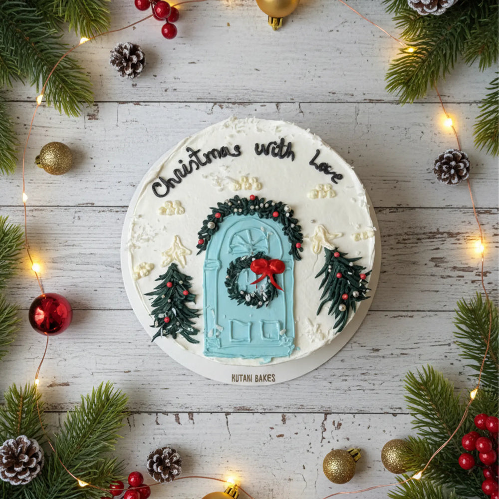 Christmas cake with Christmas door and Christmas tree decoration on top with Christmas wish on the top written