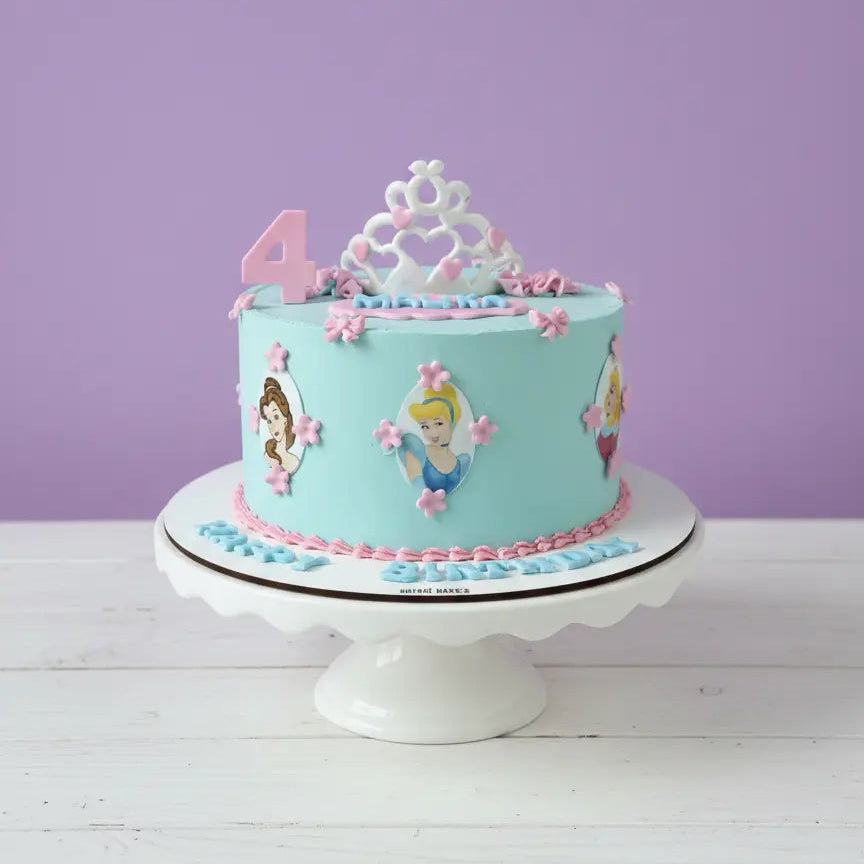 Children's birthday cake with princess design on a white stand against a purple wall.