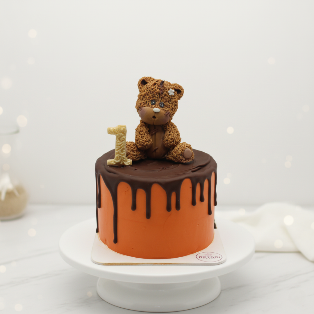 Chocolate cake with a teddy bear and number 1 on a white background