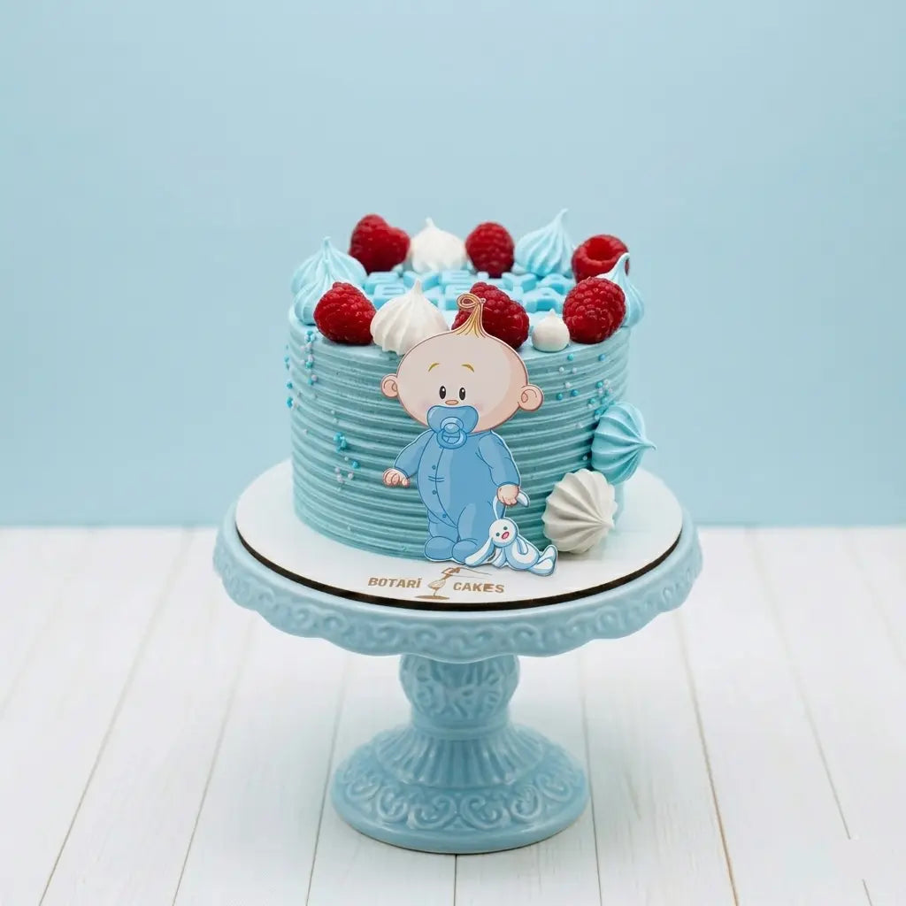 Blue baby shower cake with baby figure and berries on a light blue background
