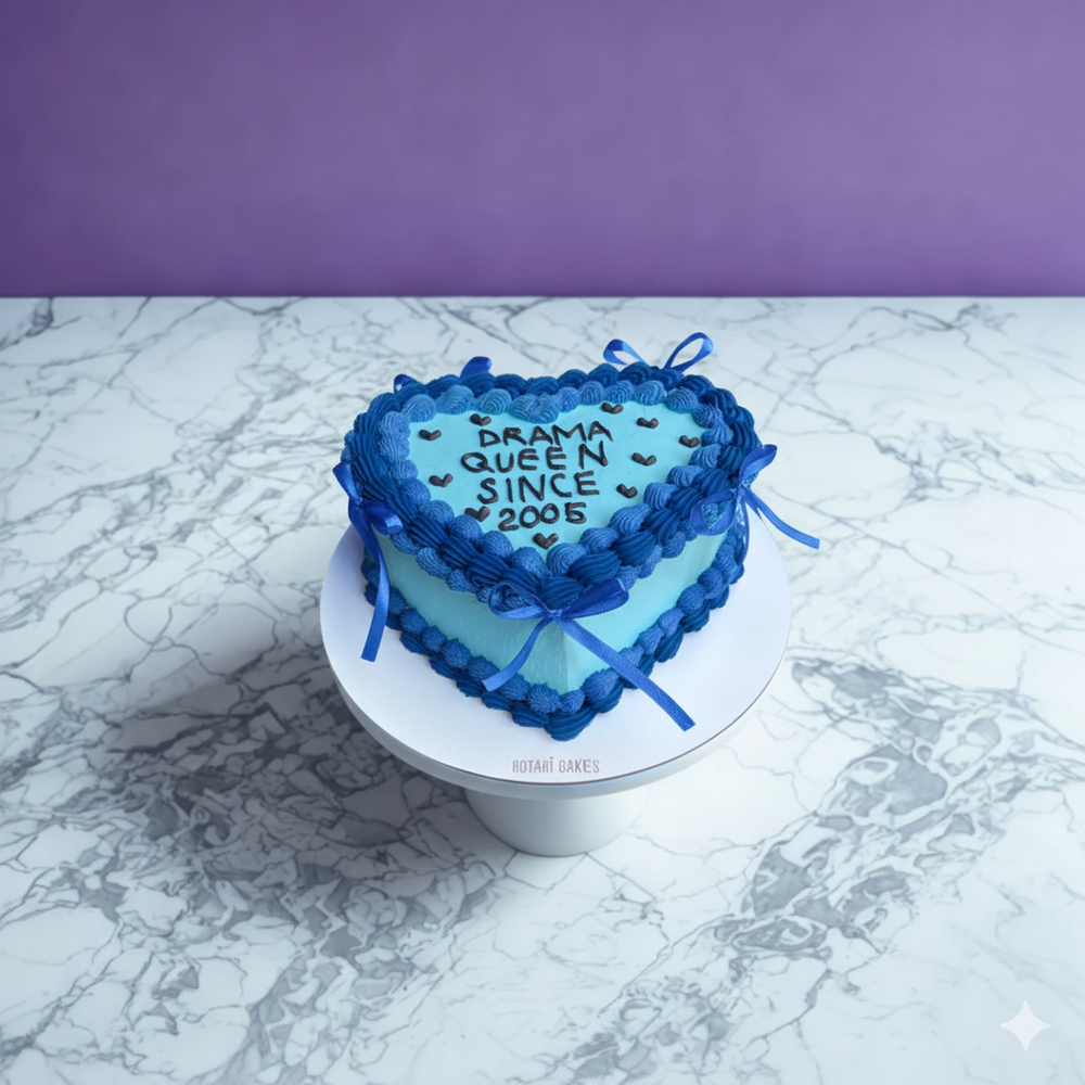 
                  
                    Heart-shaped cake with blue decorations on a marble surface with a purple background
                  
                