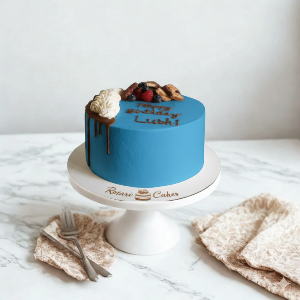 
                  
                    Blue cake with fruit toppings on a white marble surface, featuring the brand 'Rotari Cakes'.
                  
                