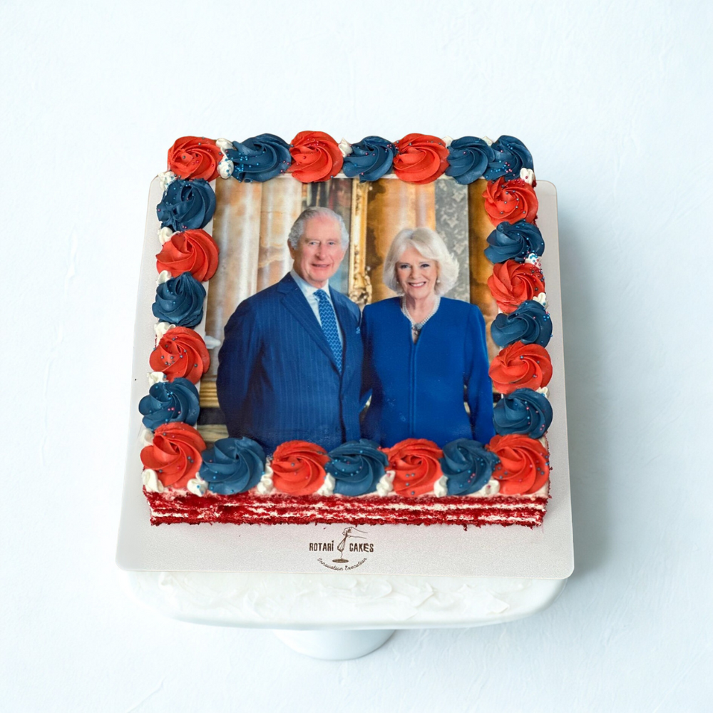 Cake with a portrait of a couple framed by red and blue roses on a white background