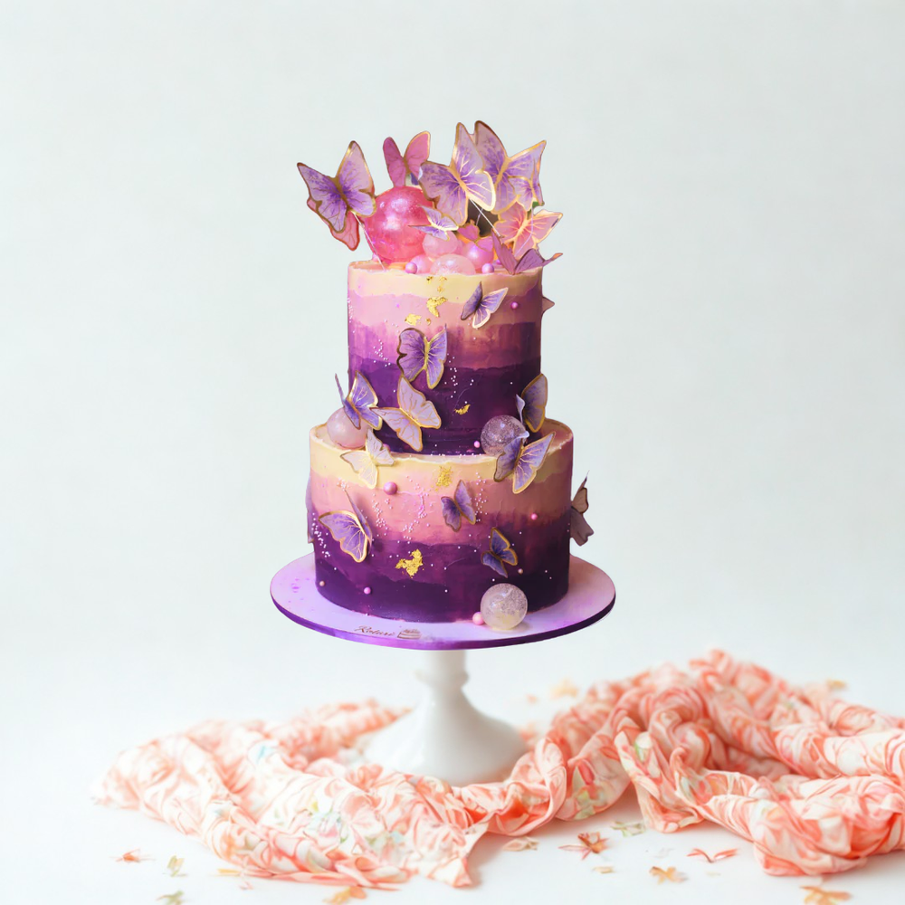 Two-tiered cake with purple and pink gradient and butterfly decorations