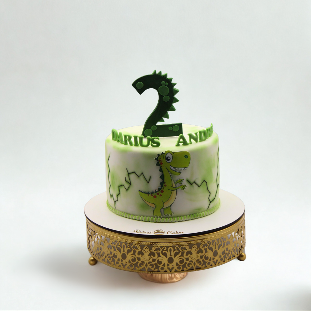 Dinosaur-themed birthday cake with a number two candle on a white background