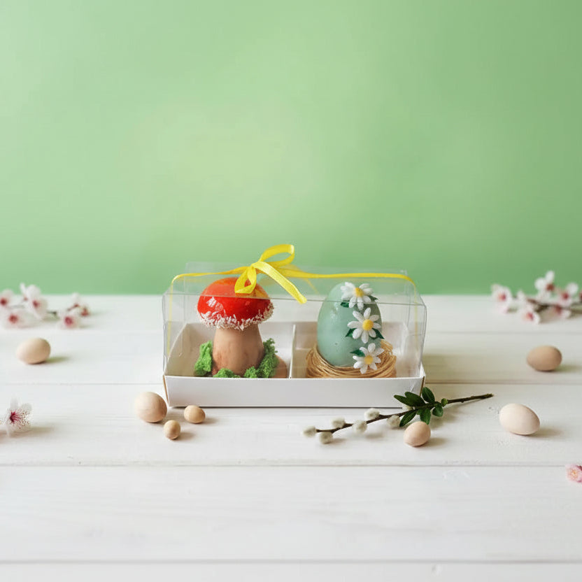 Decorative easter red mushroom and a green egg with flowers in a clear box on a light green background for easter celebration