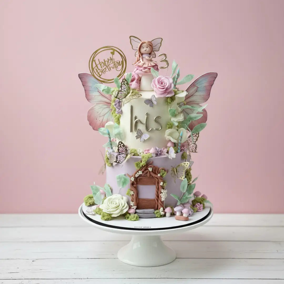 Decorative fairy cake with fairy, butterflies, and flowers on a pink background