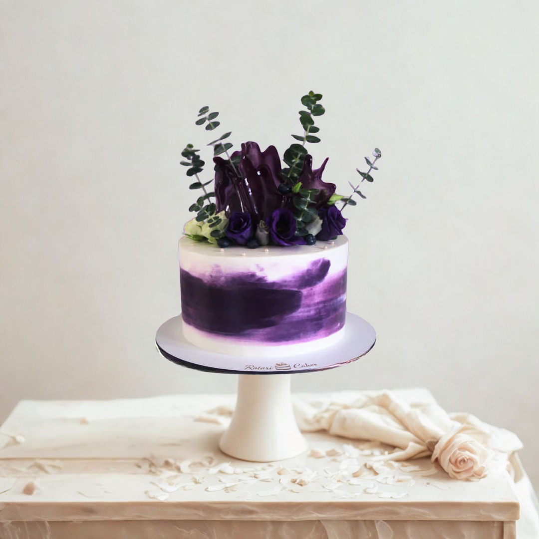 Purple and white birthday cake with floral decorations 