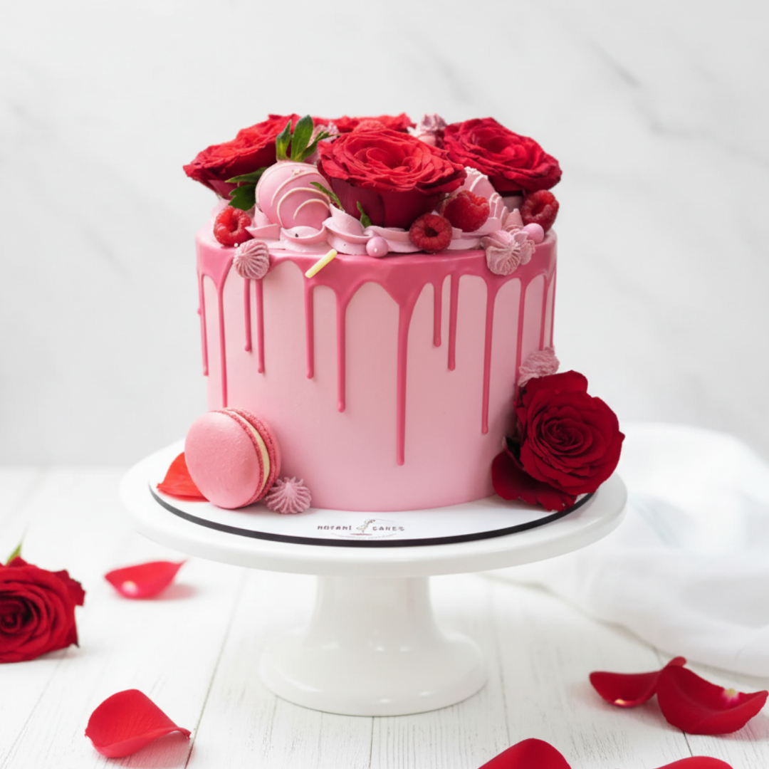 pink cake with macarons and red roses