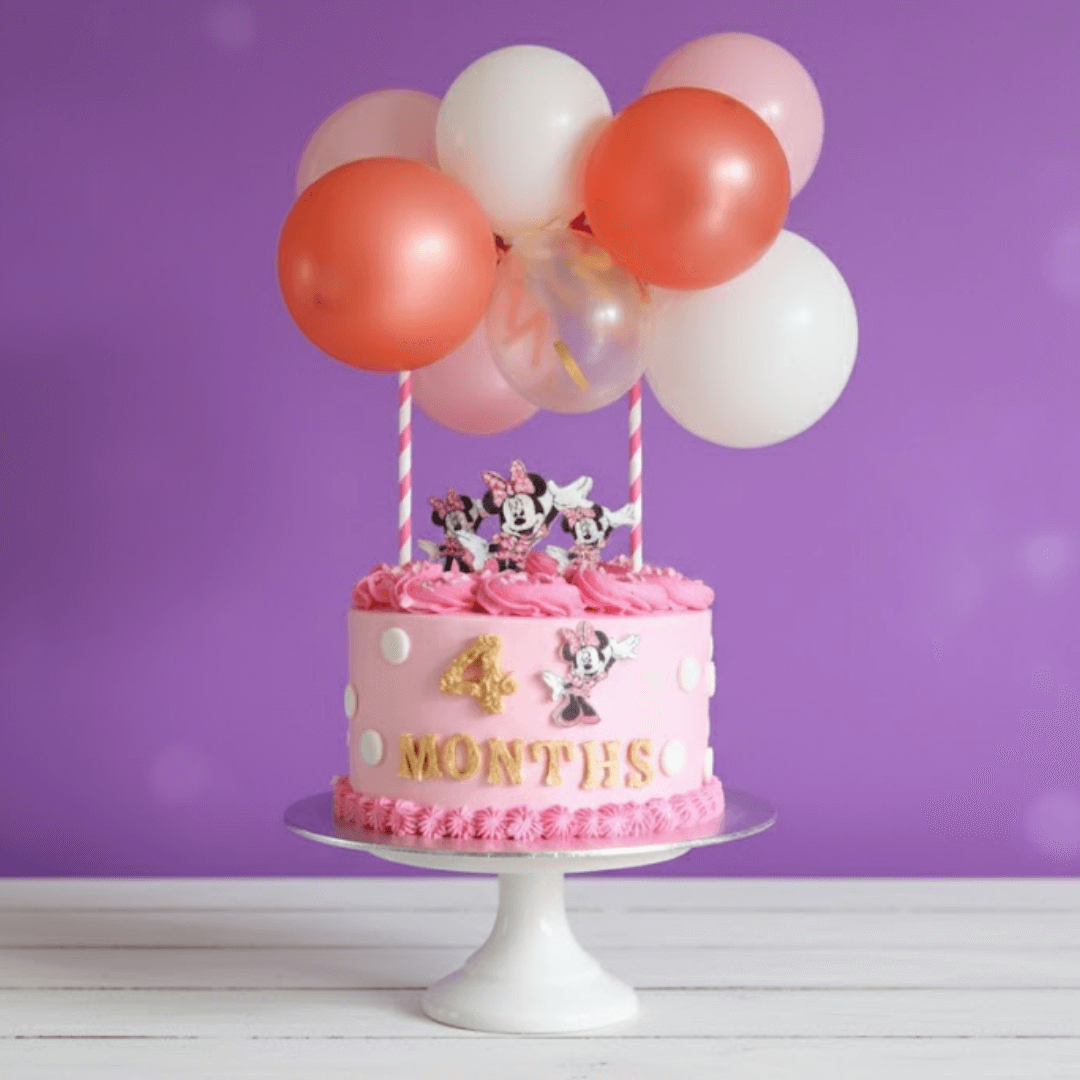 Pink Micky mouse theme birthday cake with cartoon characters and balloons on a purple background