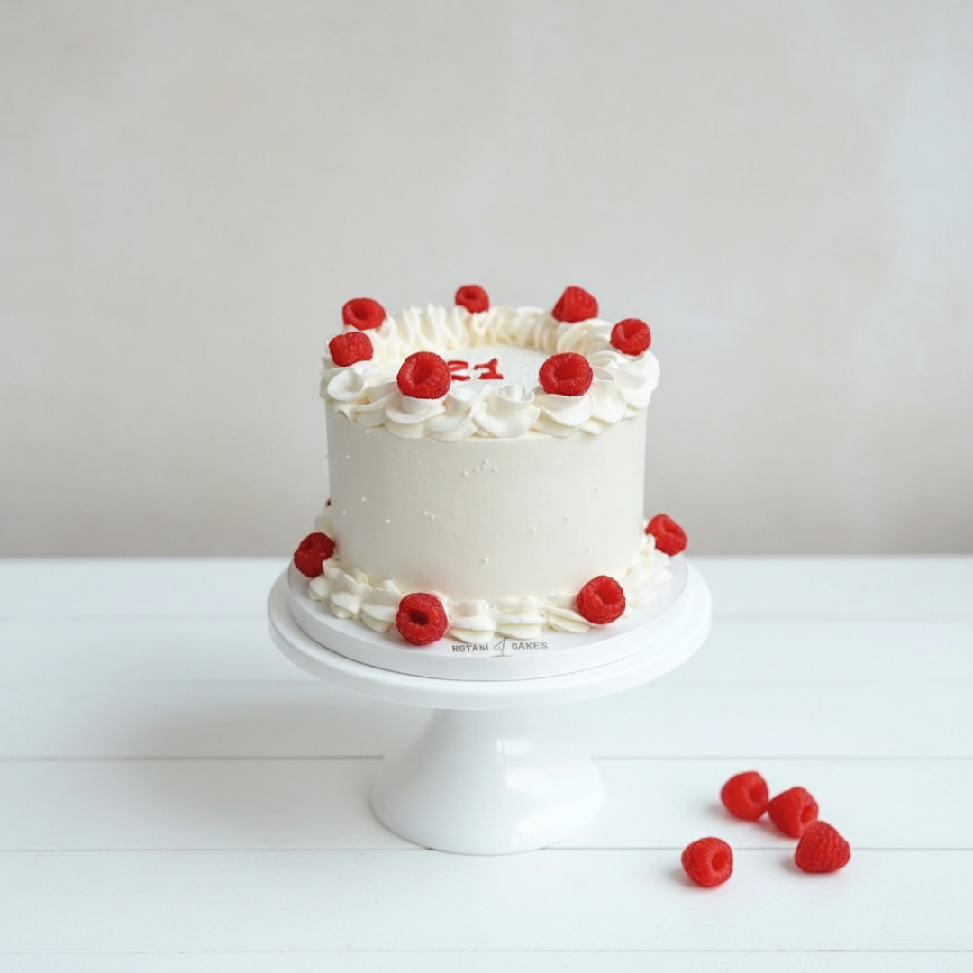 white mini cake with raspberries on top