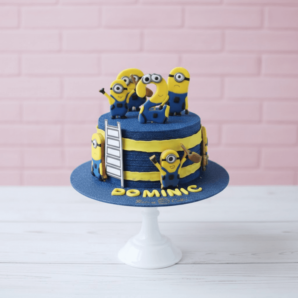Cake with Minion figures on a pink brick wall background