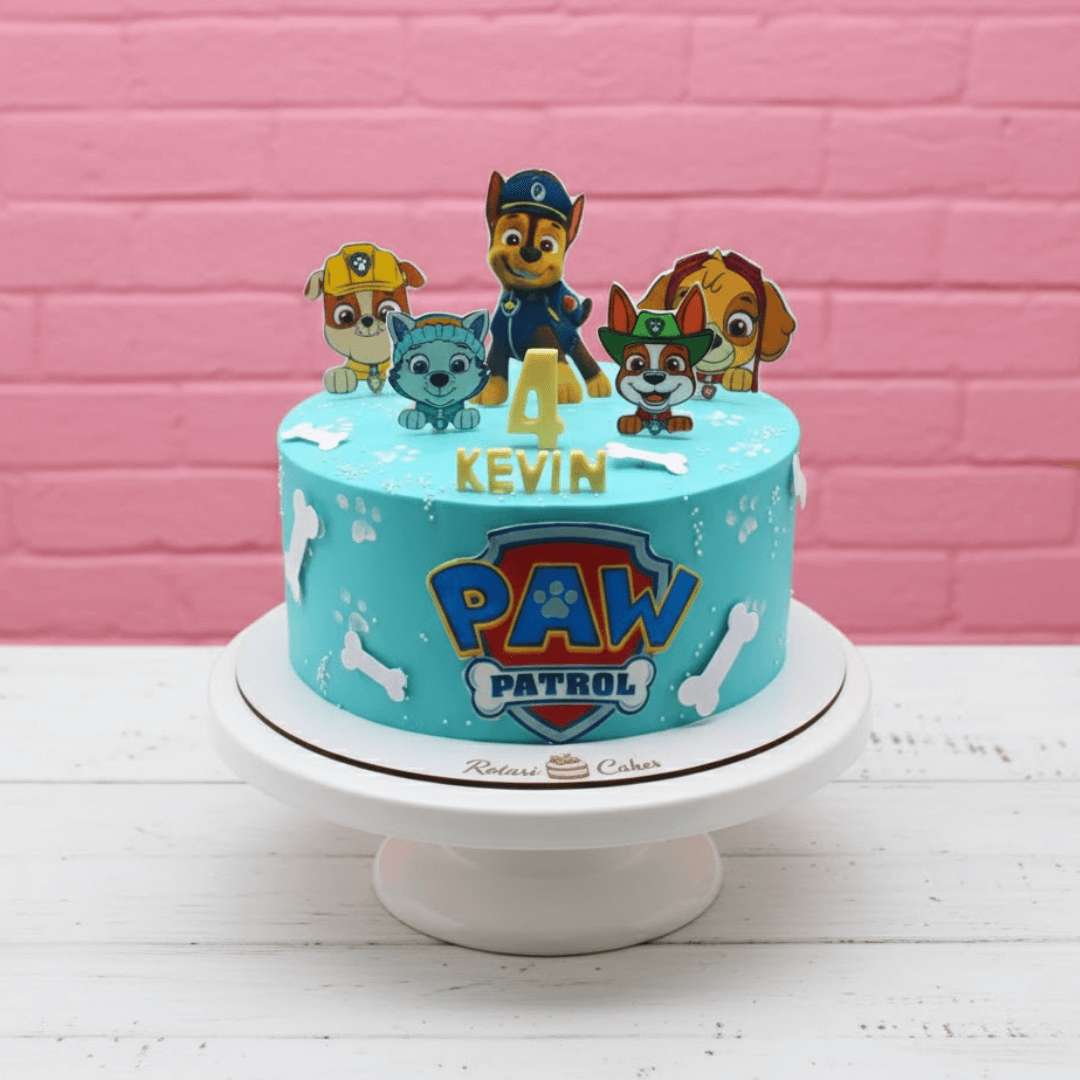 Paw Patrol birthday cake with cartoon characters on a pink brick wall background