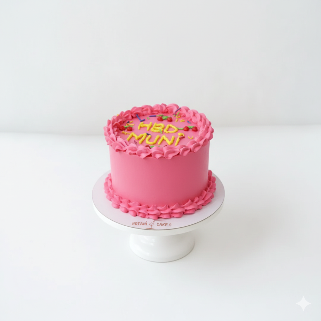 Pink cake with 'MAD MUNI' text on a white stand against a white background