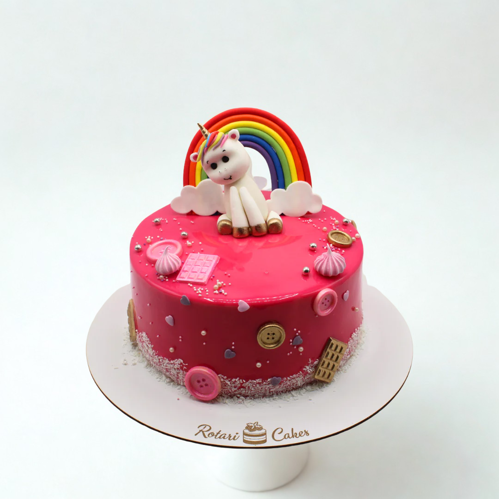 
                  
                    Pink cake with unicorn and rainbow decoration on a white background
                  
                
