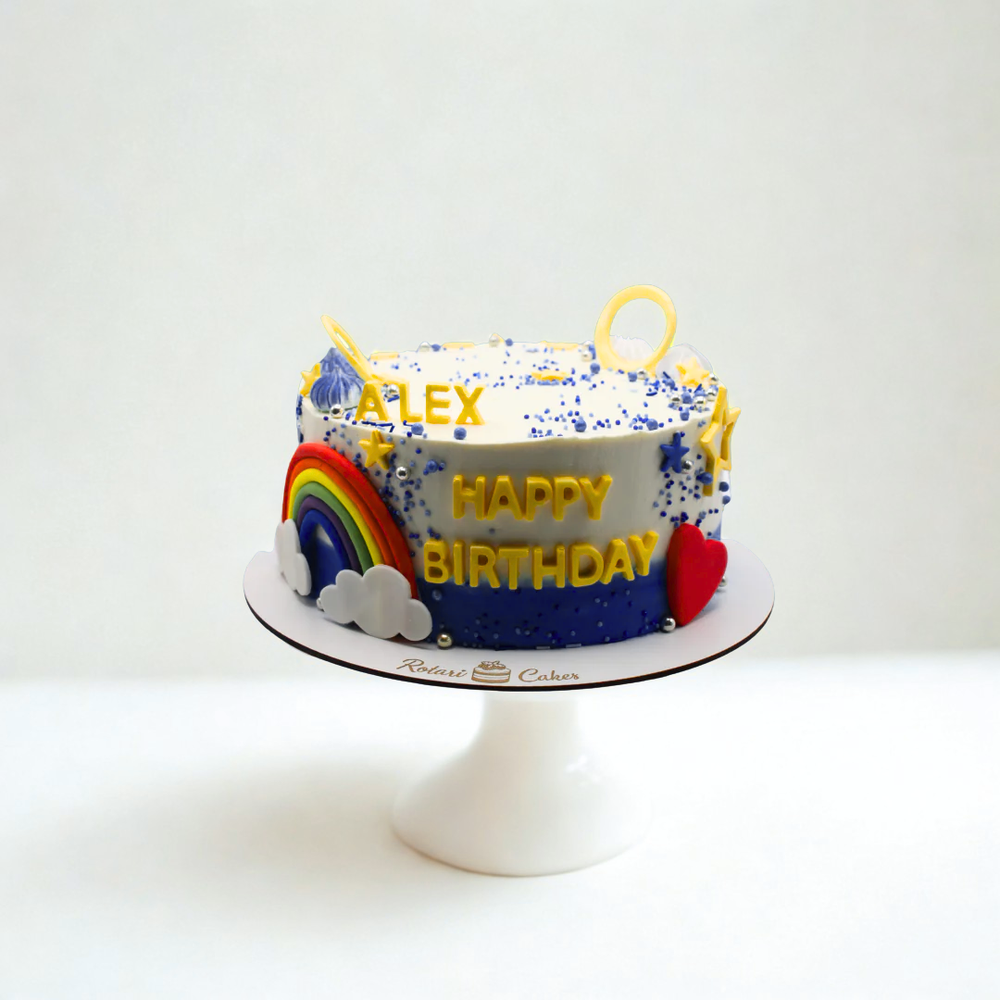Birthday cake with rainbow, clouds, and colorful decorations on a white background