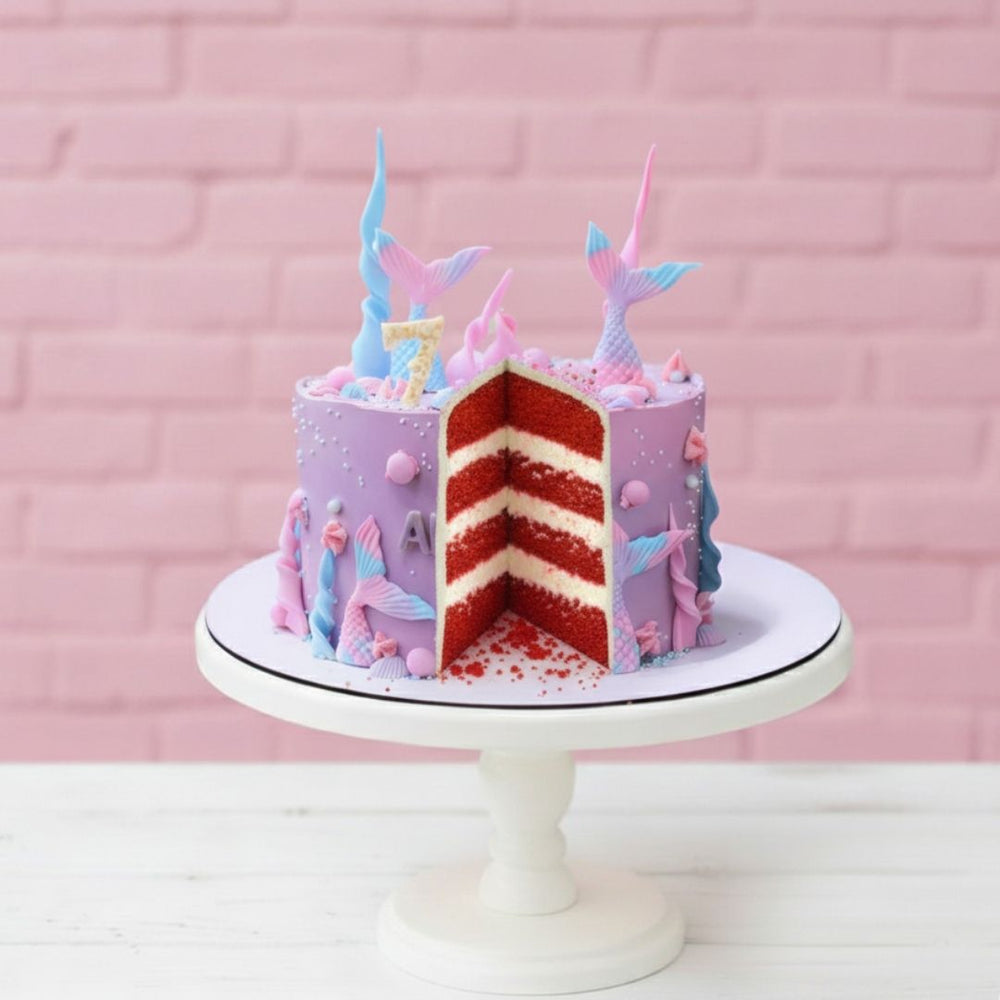 Colorful unicorn-themed birthday cake on a white stand with a pink brick background