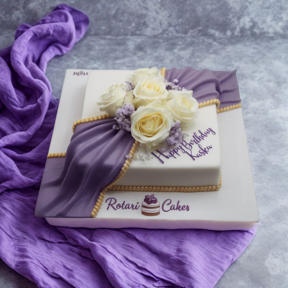 
                  
                    Decorative cake with white roses, purple accents, and 'Happy Birthday' text
                  
                