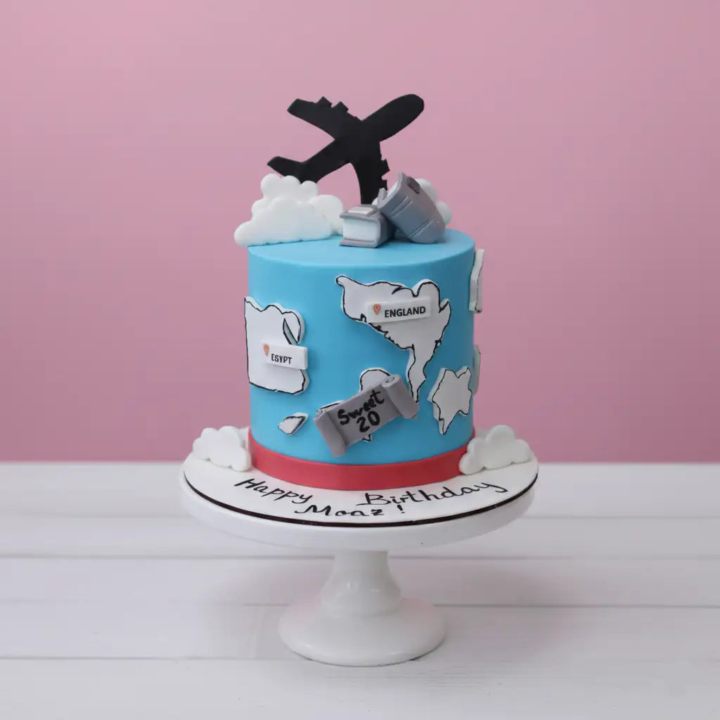 travel theme Birthday cake with travel-themed decorations on a pink background