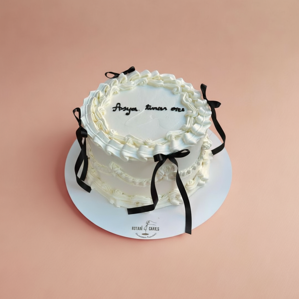 White piping cake with black ribbons 