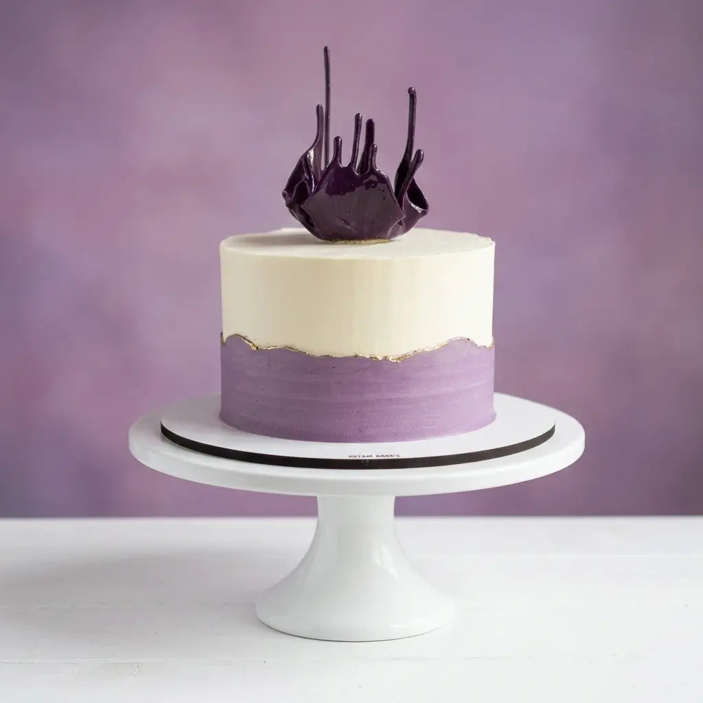 White and purple cake on a white stand with a purple background