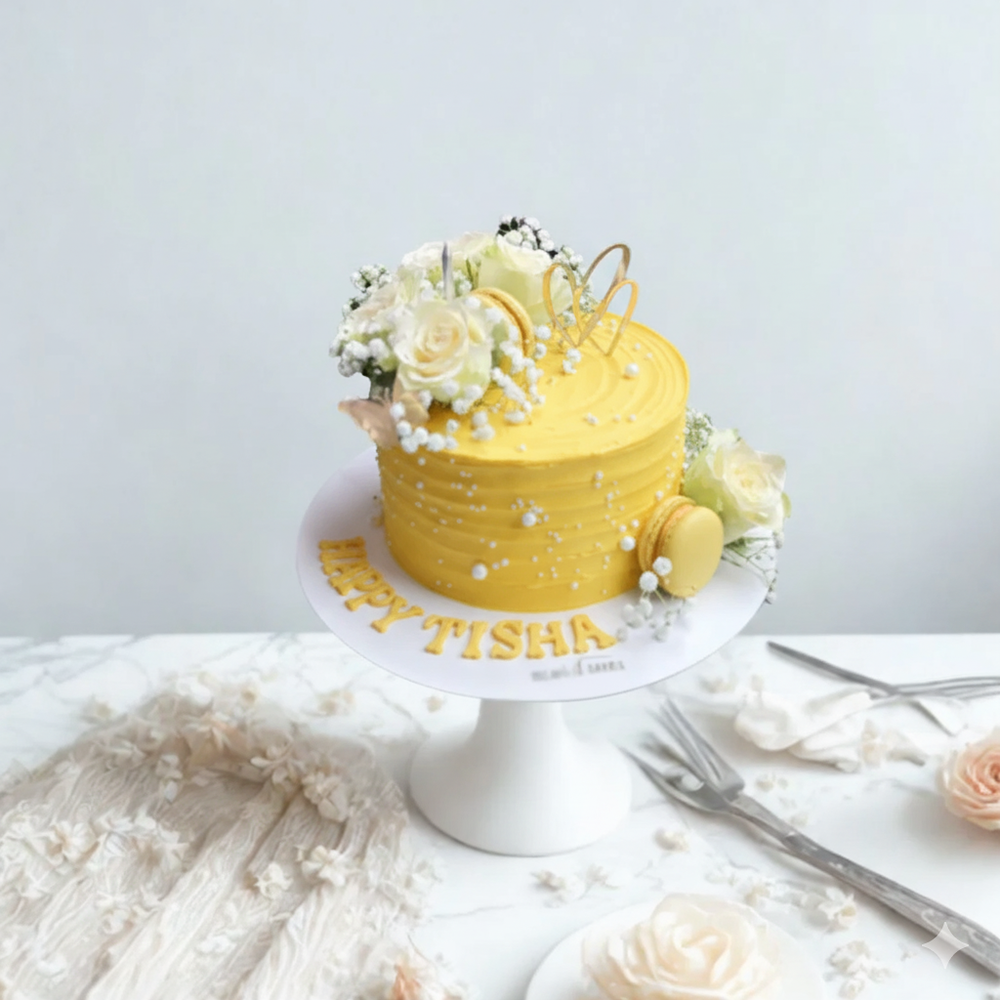 
                  
                    Yellow cake with floral decorations on a white stand against a light gray background
                  
                