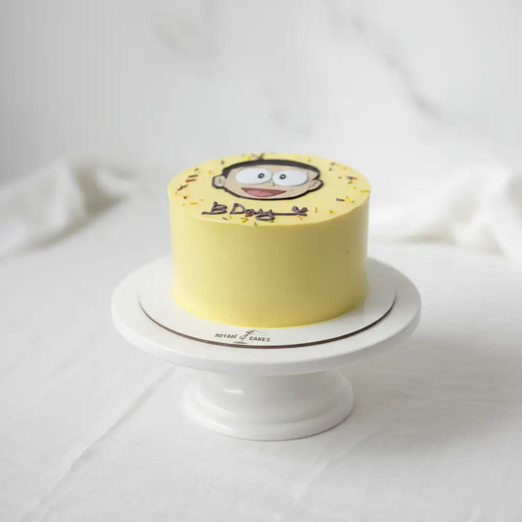 Yellow cake with a cartoon character on a white stand against a light background